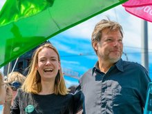 Robert Habeck (Bundesvorsitzender der Grünen) und Anna Cavazzini (Europakandidatin der Grünen) sind auf dem Foto neben einander zu sehen. Im Hintergrund weht eine grüne Parteifahne.