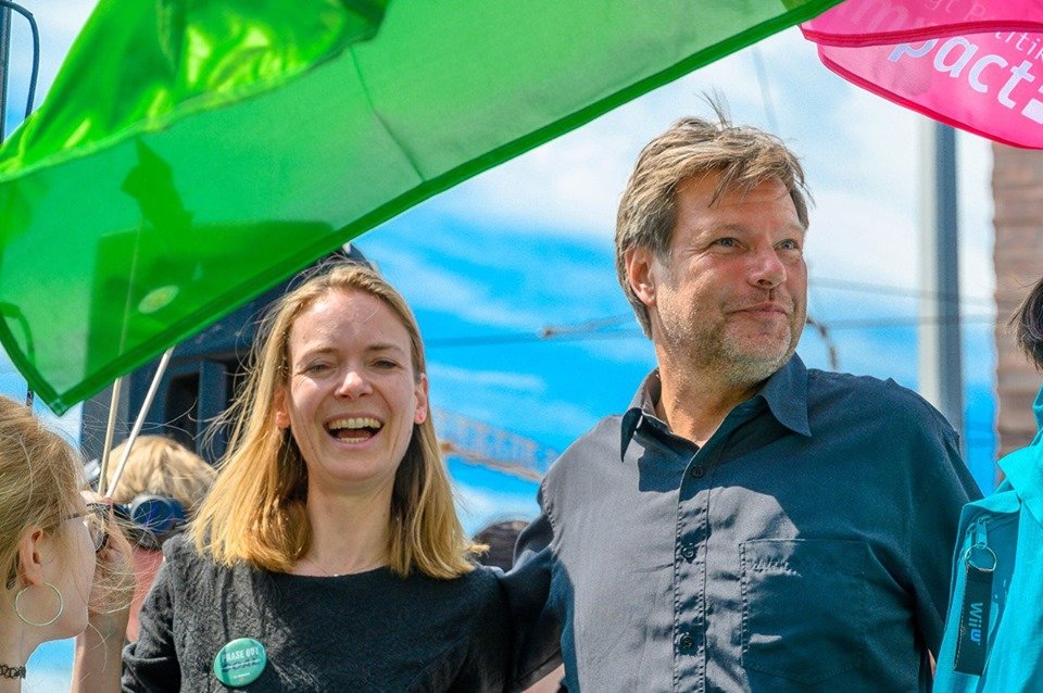 Robert Habeck (Bundesvorsitzender der Grünen) und Anna Cavazzini (Europakandidatin der Grünen) sind auf dem Foto neben einander zu sehen. Im Hintergrund weht eine grüne Parteifahne.