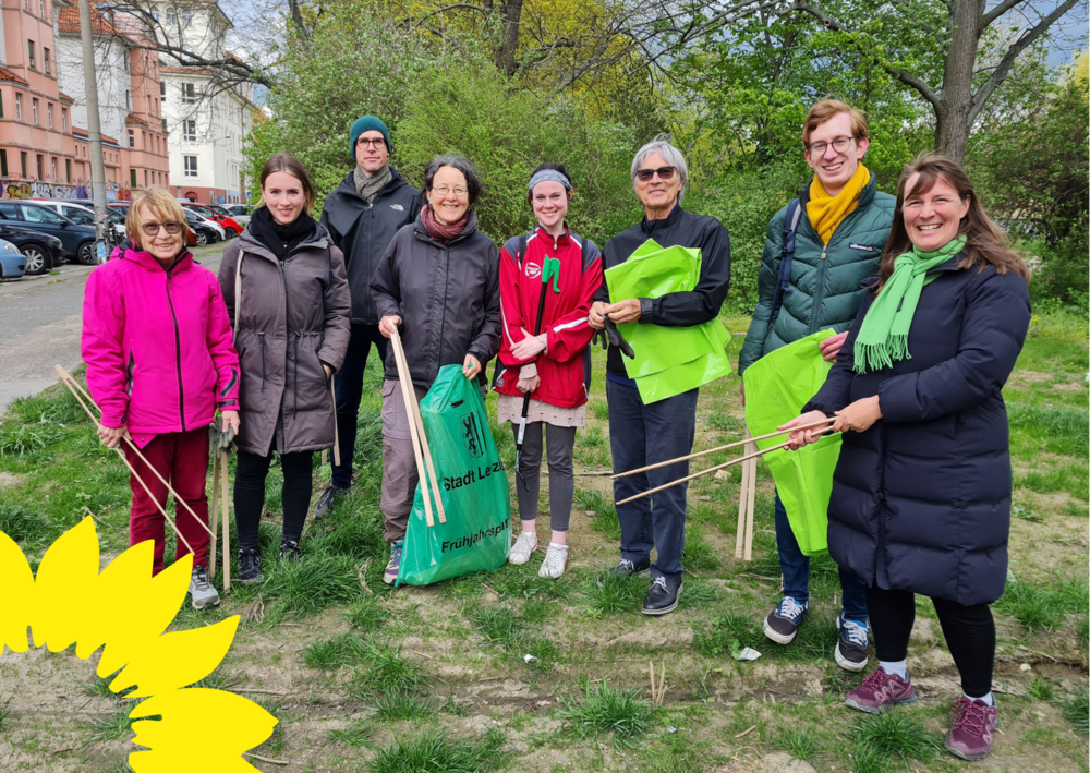 !B Sieben Frauen und Männer in bunten Jacken mit hölzernen Greifzangen und grünen Mülltüten der Stadtreinigung Leipzig.