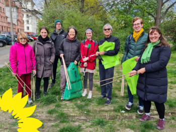 !B Sieben Frauen und Männer in bunten Jacken mit hölzernen Greifzangen und grünen Mülltüten der Stadtreinigung Leipzig.